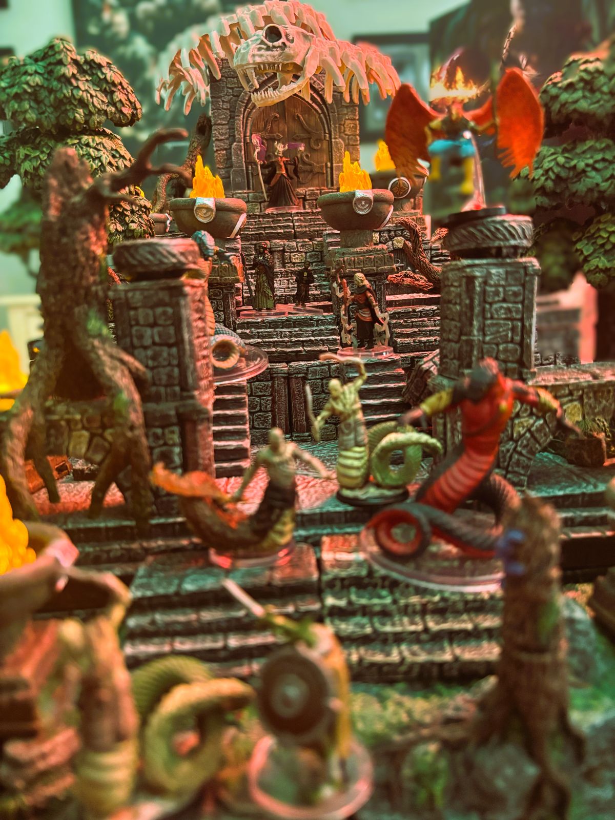 A real tabletop setup with adventurer miniatures entering an illuminated modular jungle temple